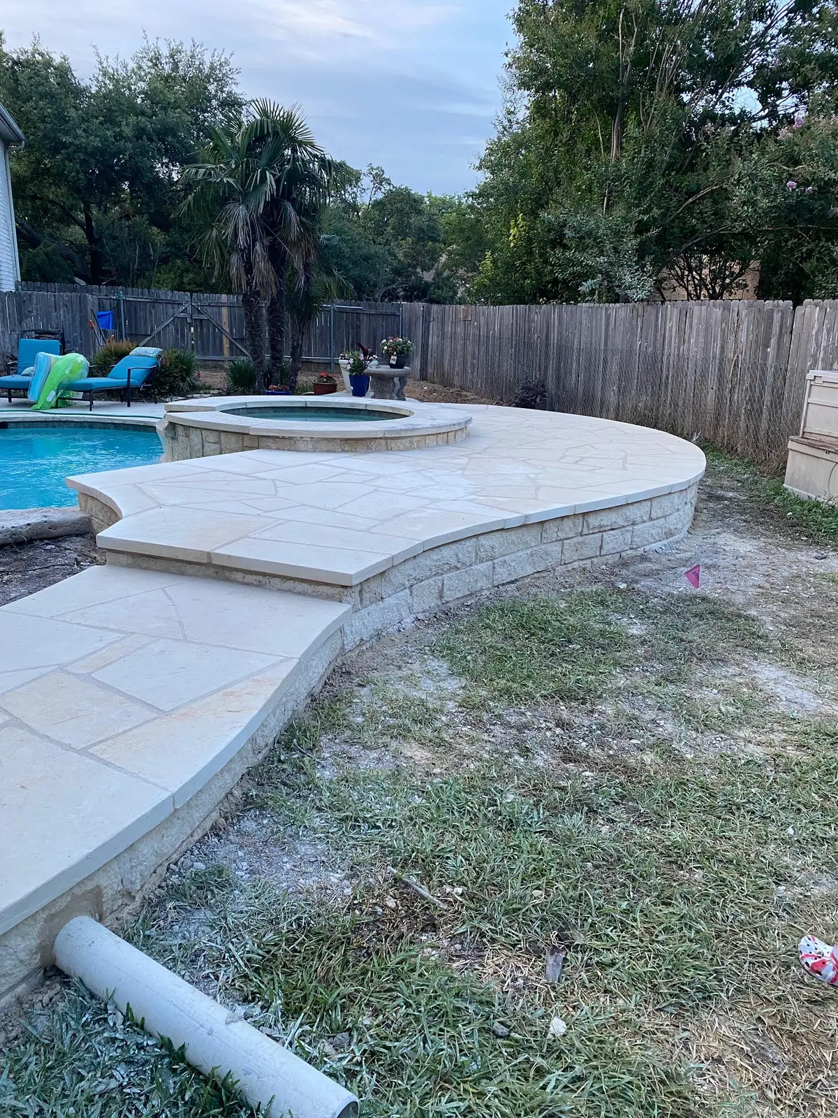 Flagstone patio and stone wall around a pool and spa